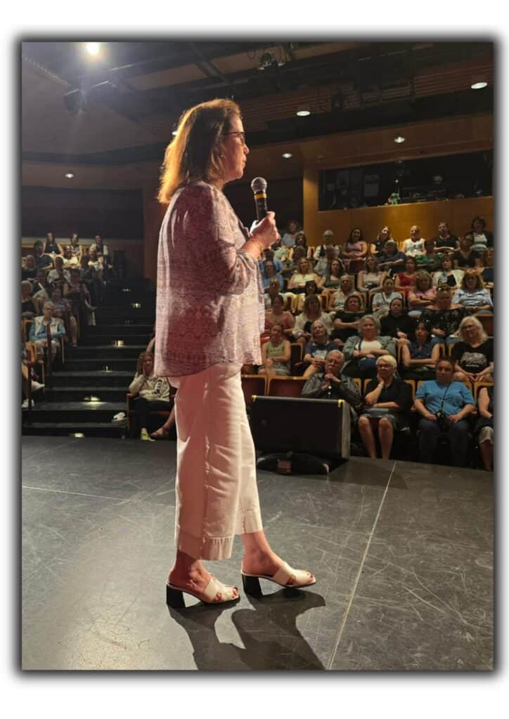 Arlene Mills holding microphone at Mary Winspear Centre in Victoria